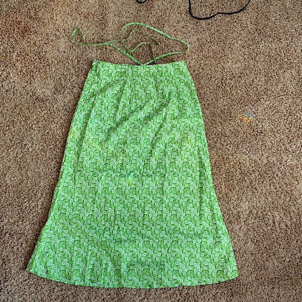 A long green skirt with waist strings at the top and white flowers.